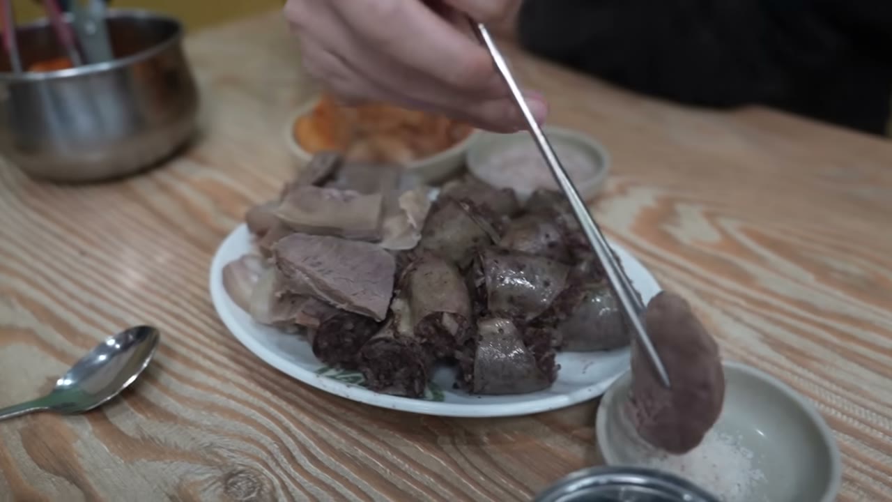젓가락으로 집어 올린 순대 한 점