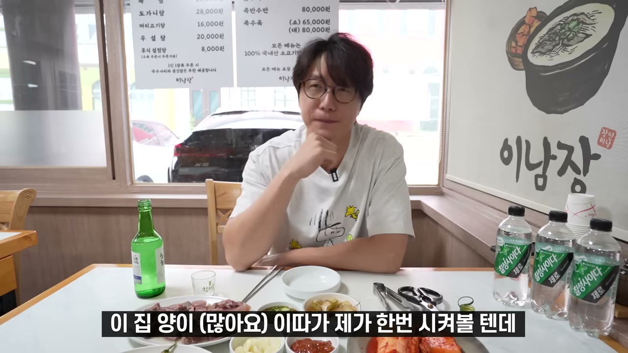 설렁탕과 김치가 깔린 상. 벽에 메뉴가 붙어 있다